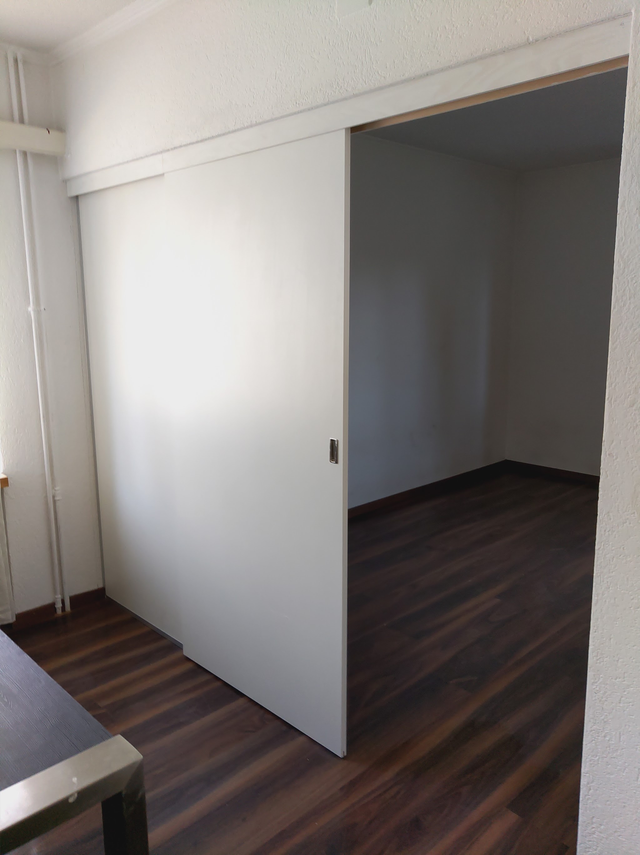 Zimmer mit Schiebetür und Parkettboden